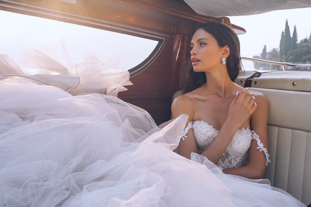 A beautiful new bride poses in a limo.