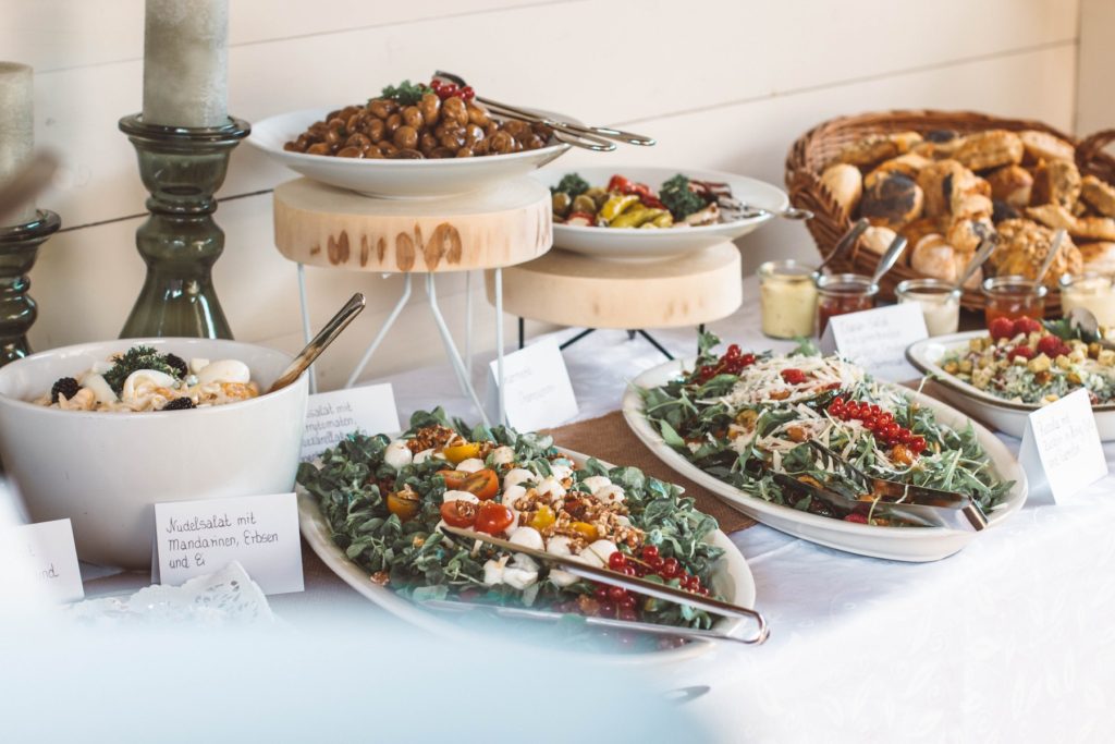 A buffet of delicious salad and cheeses at a wedding reception.