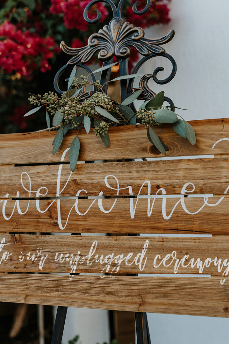 rustic wood handpainted wedding sign reading welcome to our unplugged ceremony