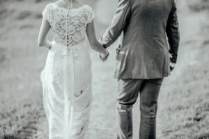 black and white portrait of newlyweds from behind on a beach