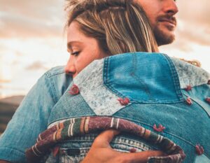 close up of woman hugging male partner looking serious