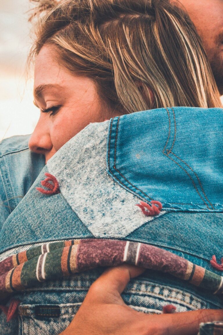 close up of woman hugging male partner looking serious