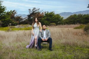 a couple in a field in formal wedding attire