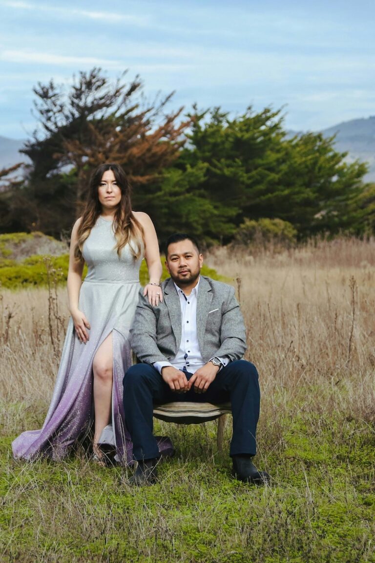 a couple in a field in formal wedding attire