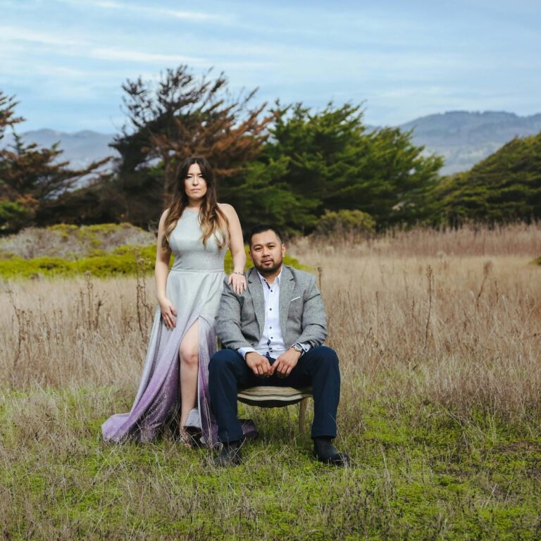 a couple in a field in formal wedding attire